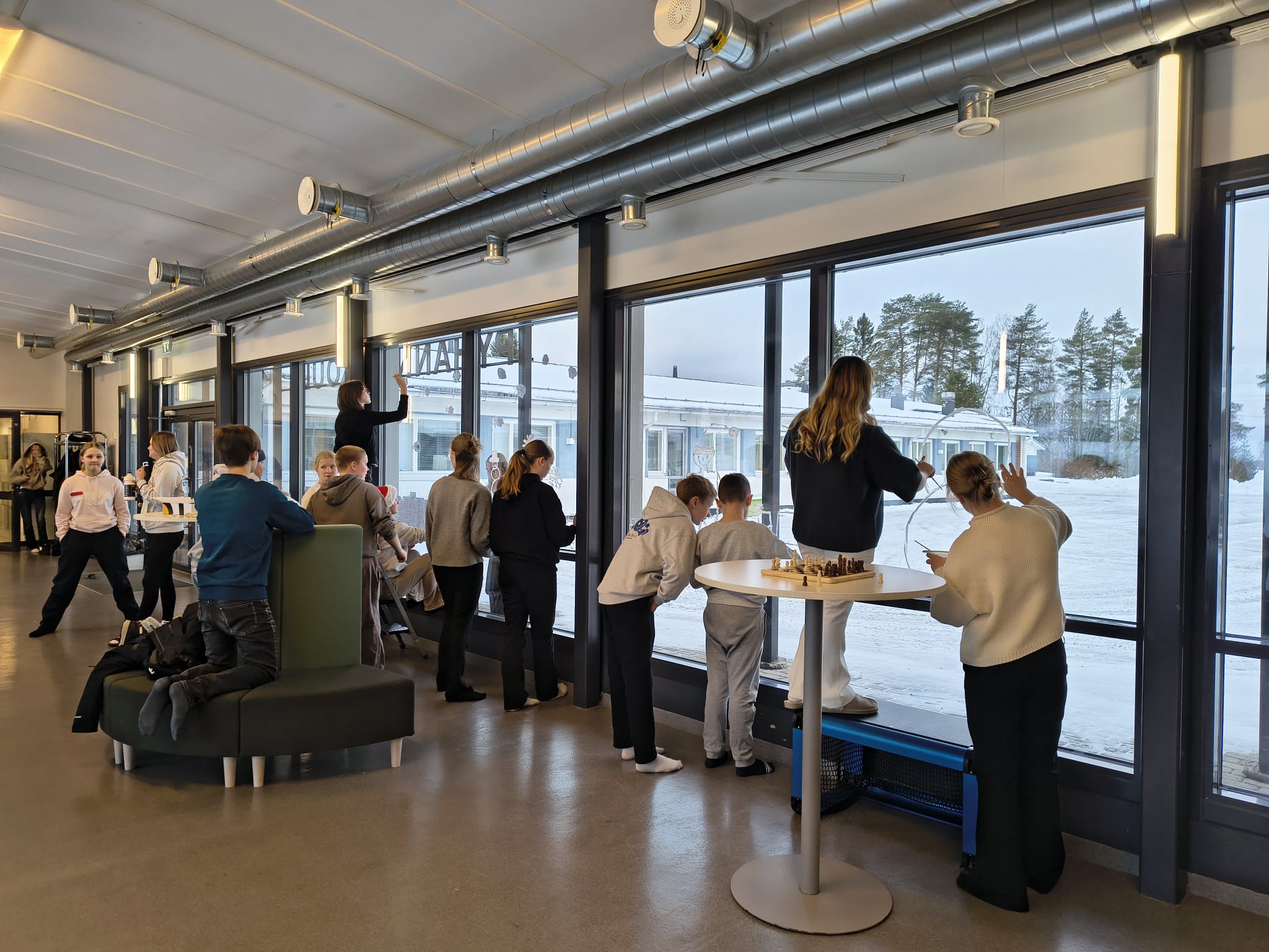 Koululaiset koristelemassa ikkunoita 